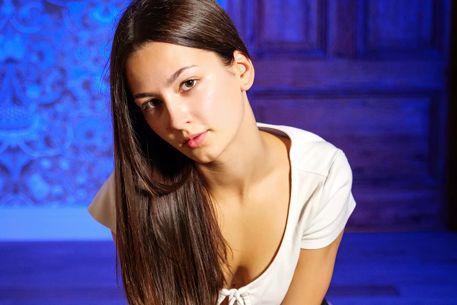 Anna Valez Captured Against A Blue-Lit Brick Wall In Video